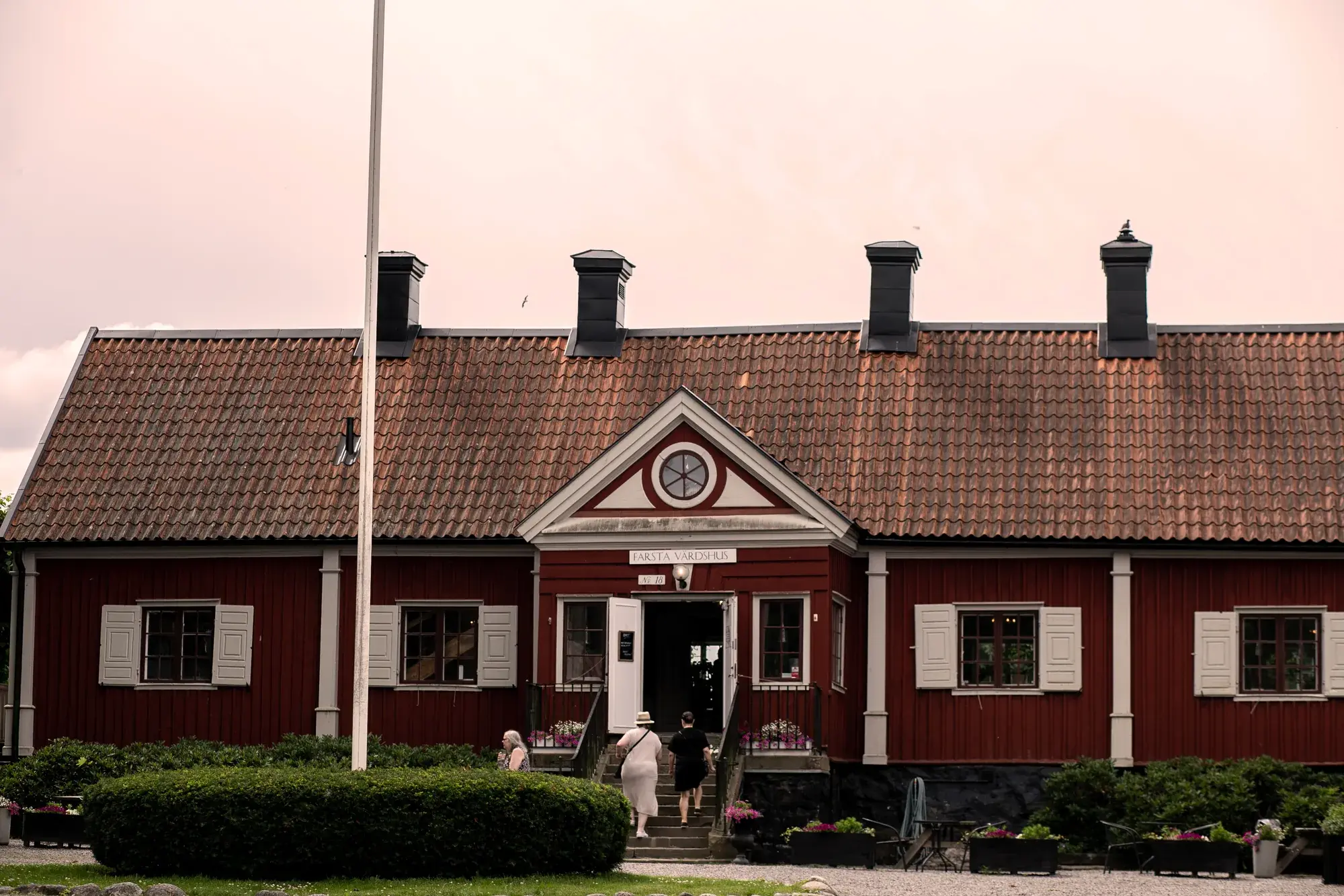 Farsta Värdshus röda fasad med gårdsplan och entré