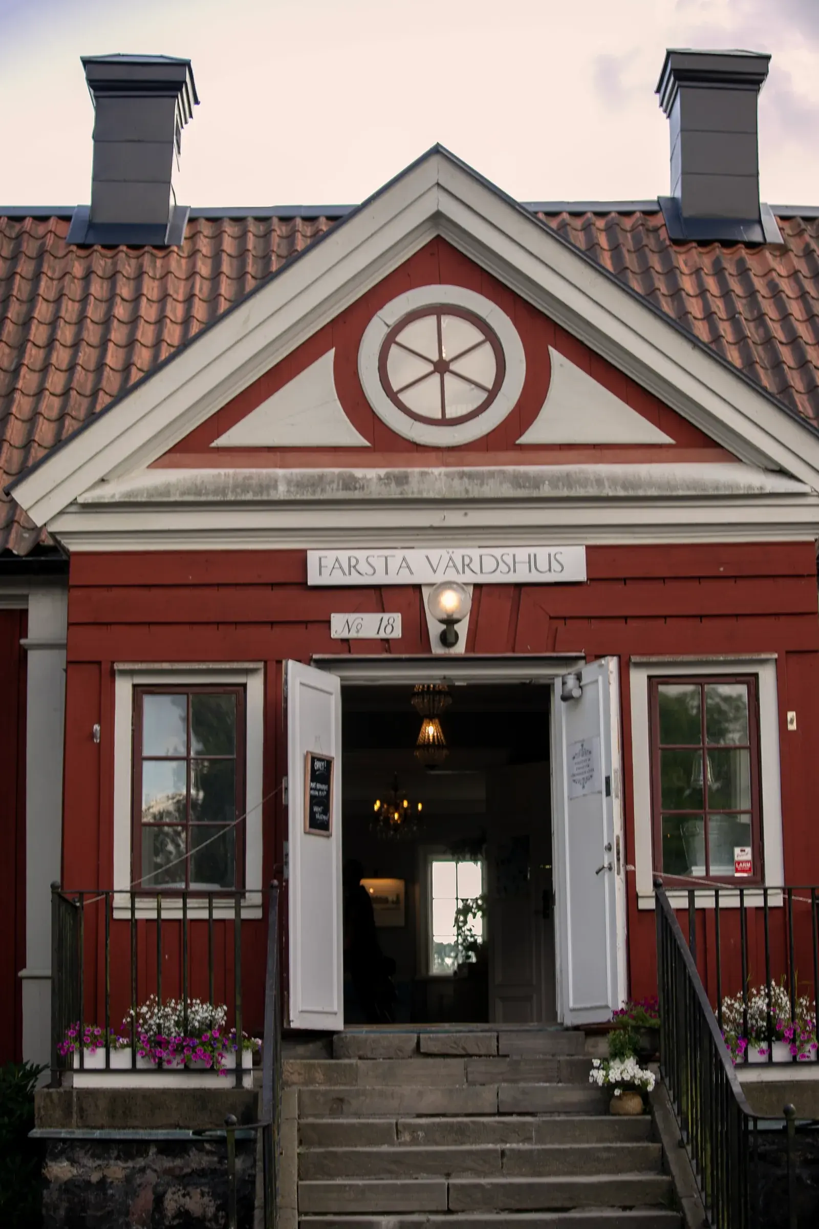 Entrén till Farsta Värdshus med trappor och röd fasad
