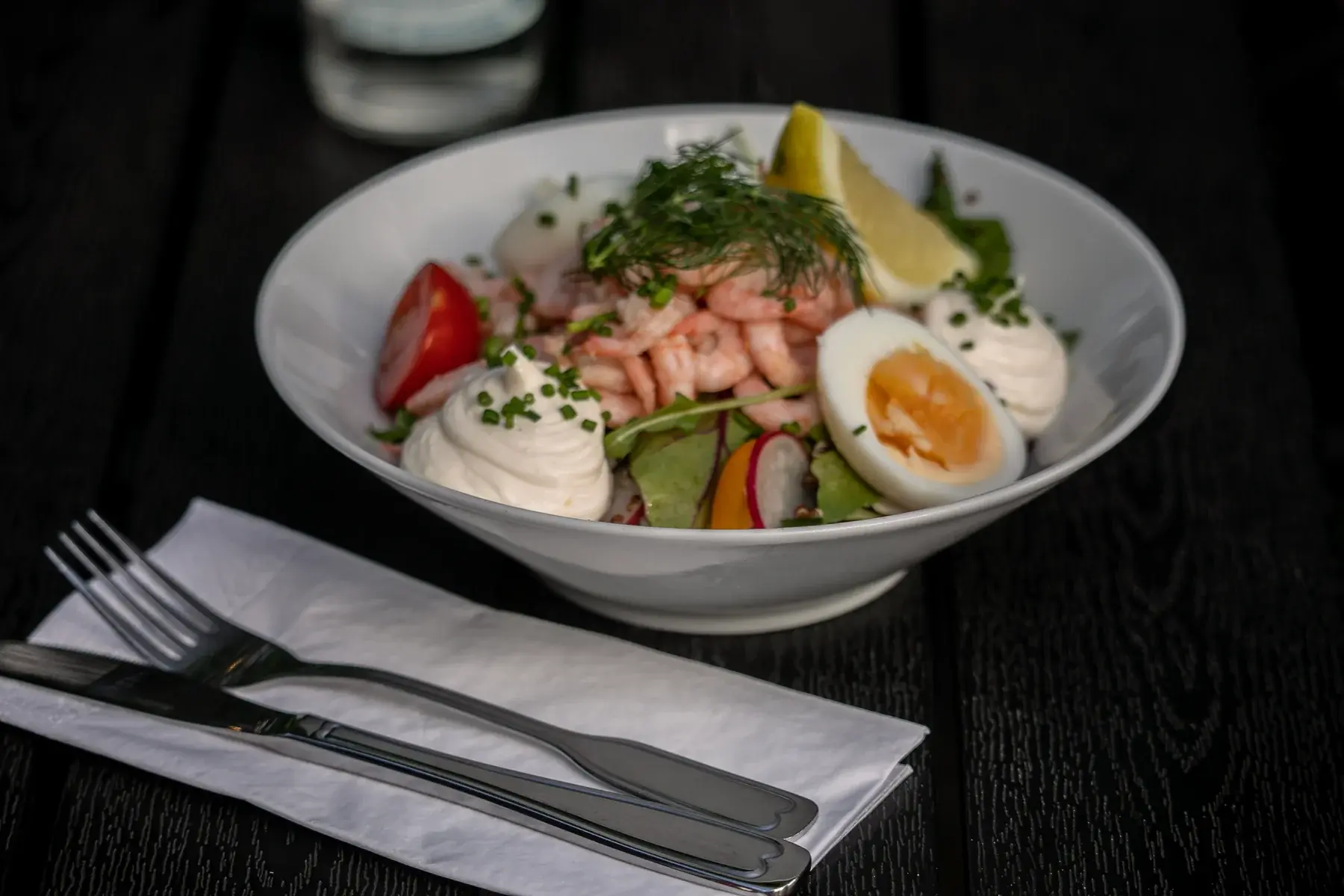 Räksallad med ägg och citron på ett dukat bord